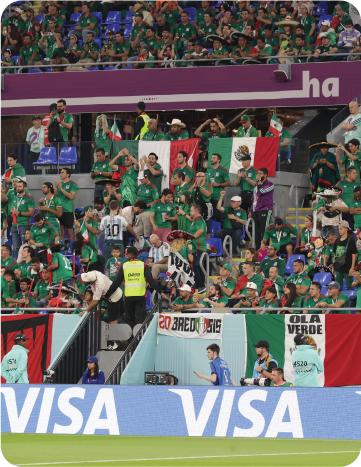 Mexican football fans in the stadium wearing national team jerseys.